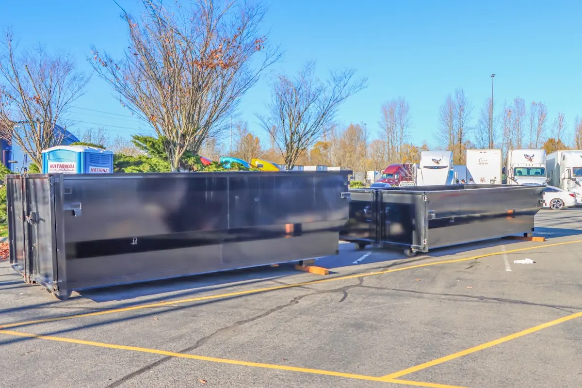 Professional dumpster rental service with roll-off container on residential driveway in Montrose-Ghent